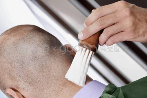理发师用刷子刷男人的脖子