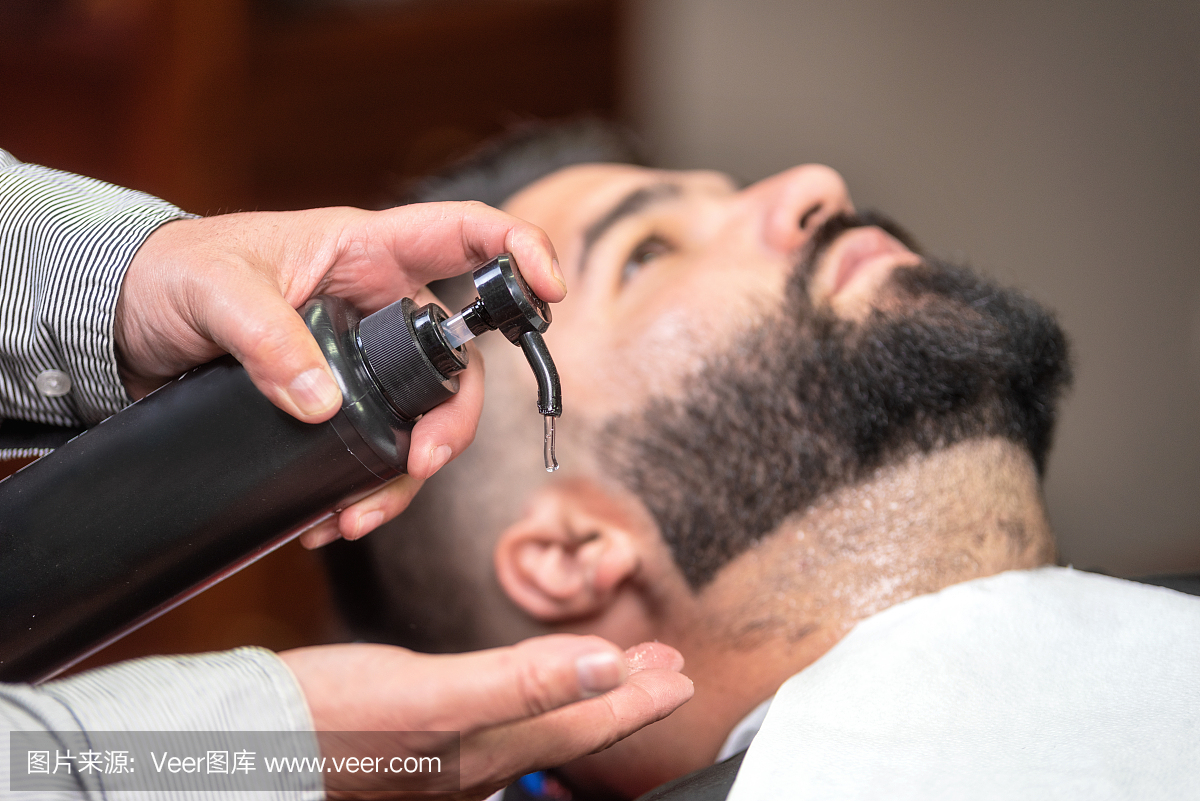 发型师在理发店使用剃须后的乳液。